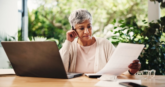 Image of a woman sitting at the table and looking at documents